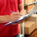 young-businessman-with-clipboard-warehouse