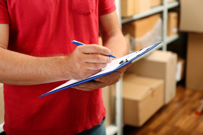 young-businessman-with-clipboard-warehouse